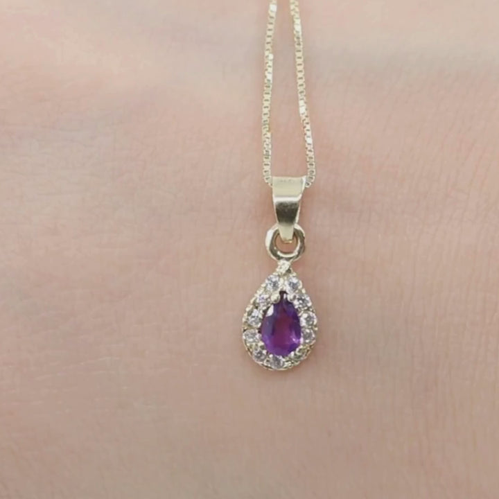 A drop-shaped halo pendant with an amethyst stone on a 14K gold chain.